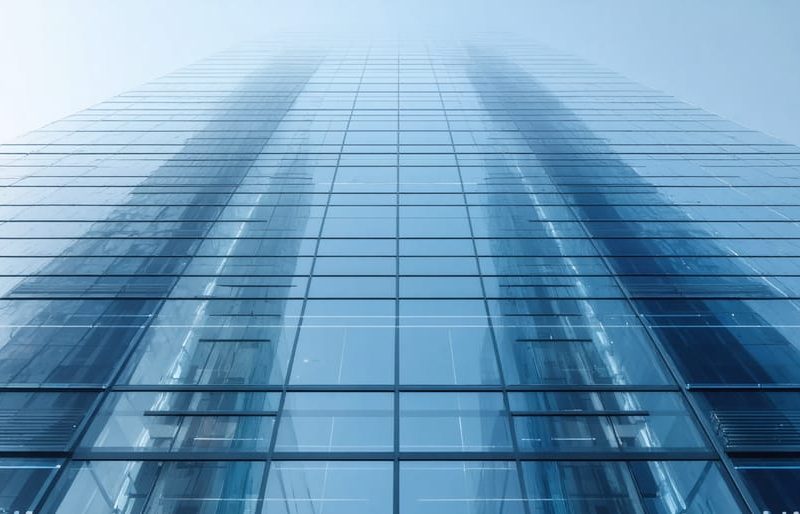 Conceptual illustration of a modern skyscraper showcasing smart glass technology, with windows shifting from clear to tinted states, highlighting energy efficiency and advanced architectural integration.