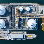Aerial view of an advanced LNG export terminal under construction in the U.S., featuring large storage tanks, modular liquefaction units, and marine loading systems along a coastal location.
