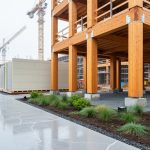 “Modern construction site with mass timber beams, advanced concrete elements, and modular building panels under soft daylight.”
