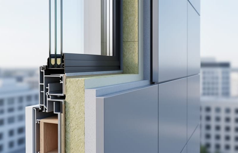 Close-up of a modern building exterior envelope showing insulated wall layers, high-performance window glazing, and ventilated cladding panels in soft daylight.